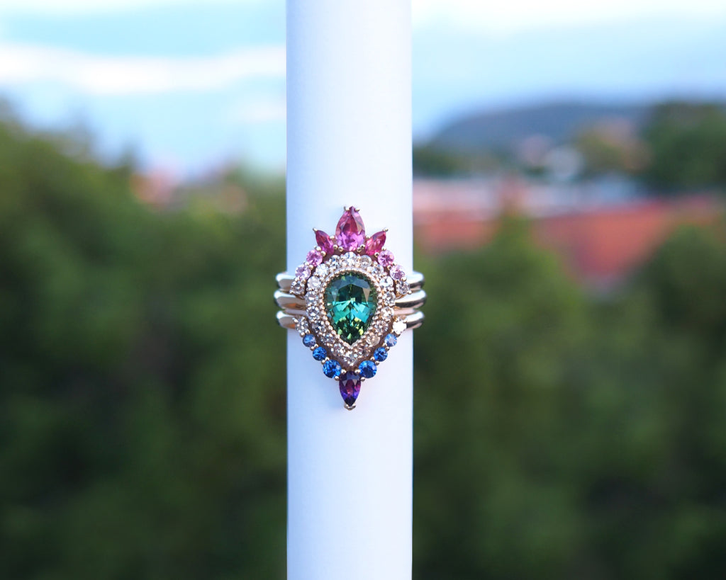 Cocktail ring featuring green tourmaline, diamonds, and sapphires, showcasing a non solitaire engagement ring design.