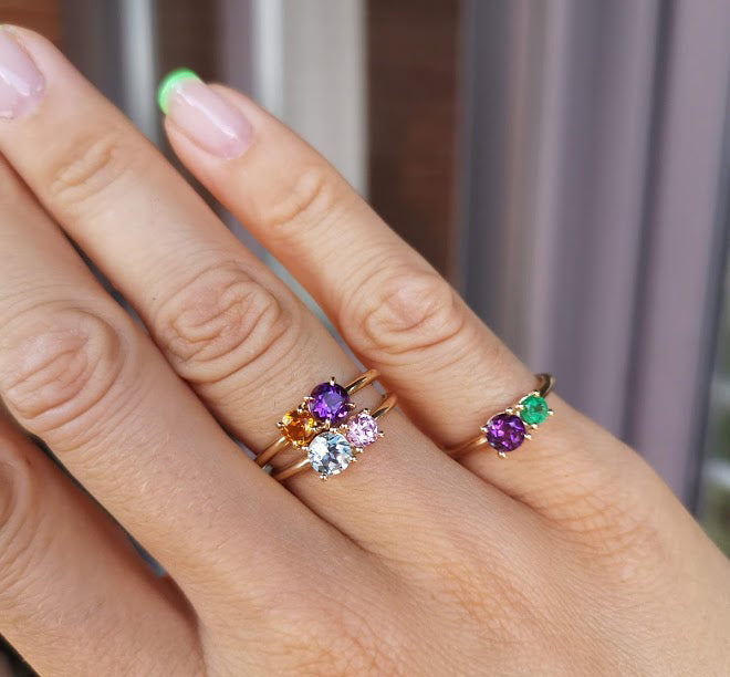 Woman wearing the Iris Flower Ring in solid 14k yellow gold with genuine amethyst and citrine from Lico Jewelry Montreal paired with other rings