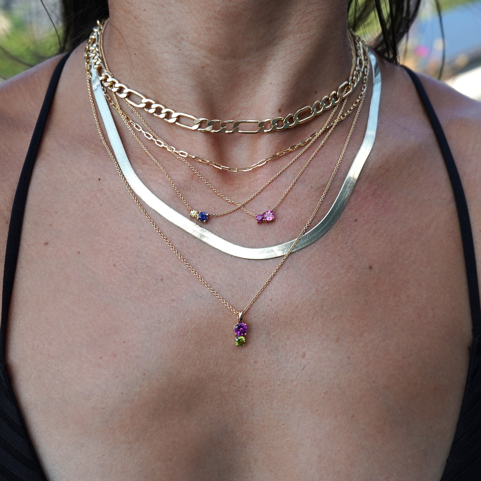 Woman's neck adorned with Lico Jewelry's 2 stone necklace in solid 14k yellow gold featuring genuine pink tourmaline and rubelite on a 16-inch rolo chain, made in Montreal.