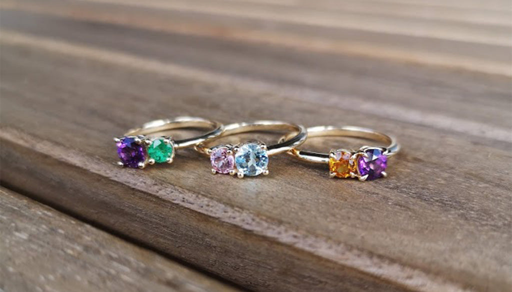 Three Lico Jewelry 2 stone rings including Lost Galaxy Ring on wooden surface