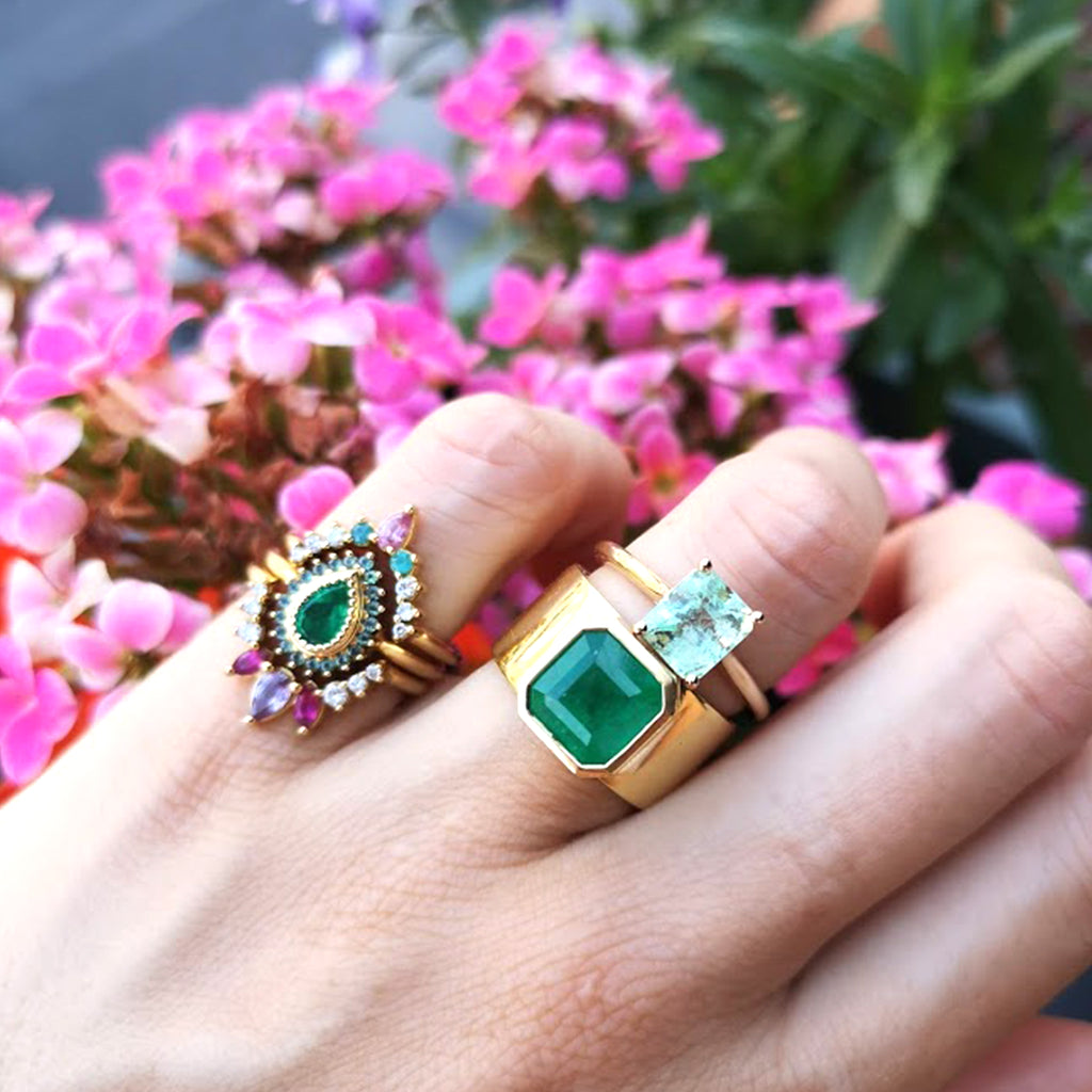 Lico Jewelry's Mint Solitaire ring with 1.57 ct Colombian emerald on woman's wedding finger layered with another Lico ring on her pinky finger