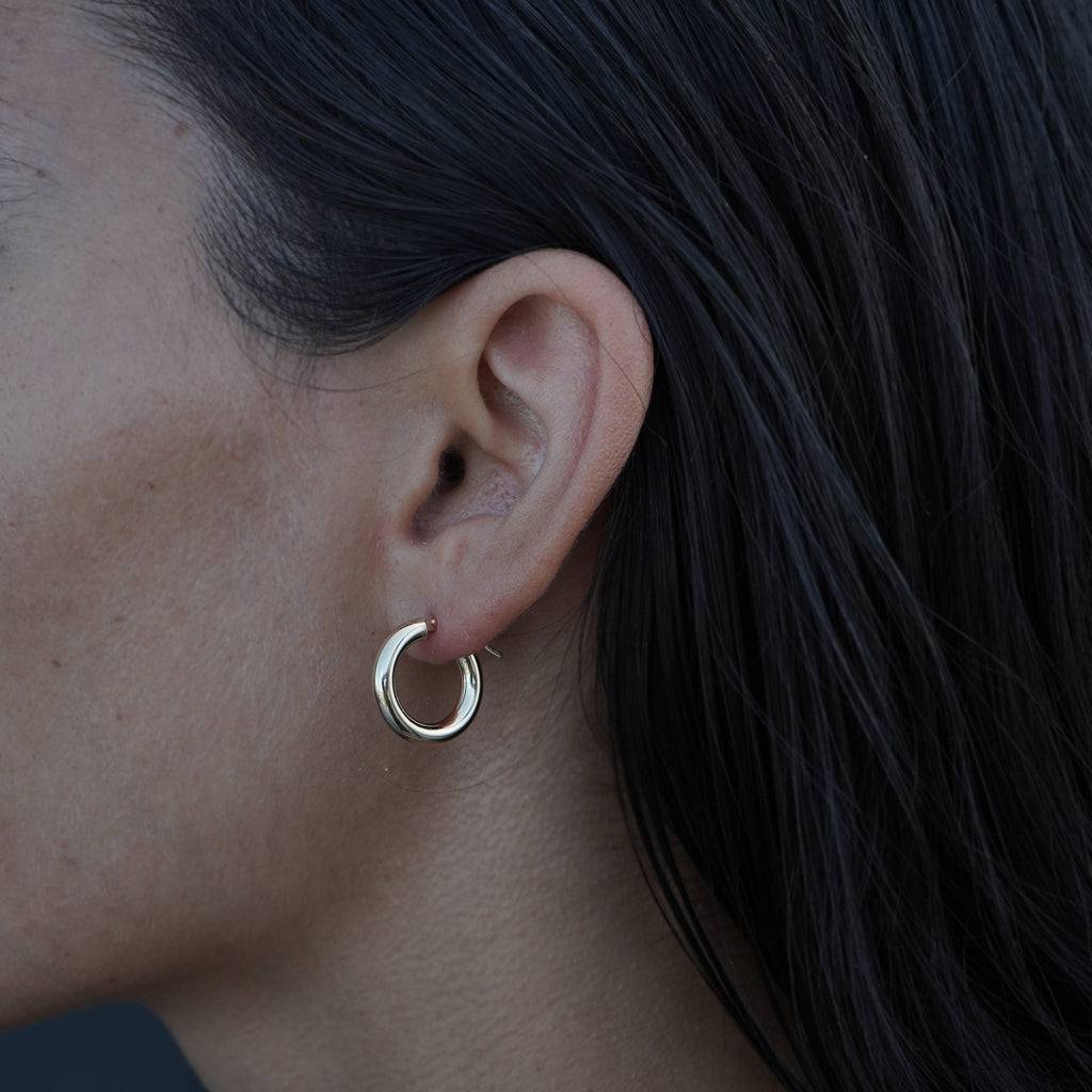 14K yellow gold earrings from Lico Jewelry, featuring a model wearing the hoops