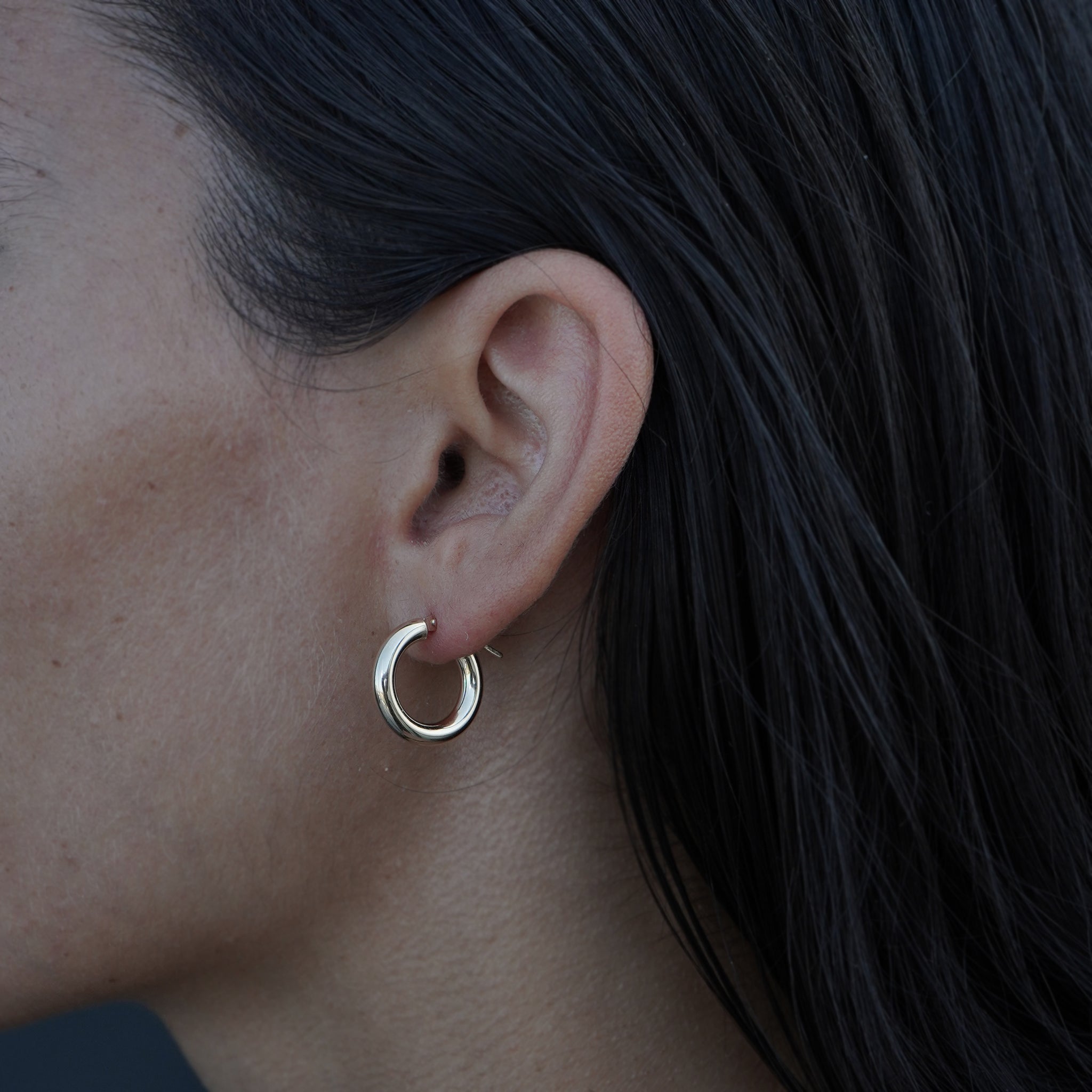 14K yellow gold earrings from Lico Jewelry, featuring a model wearing the hoops