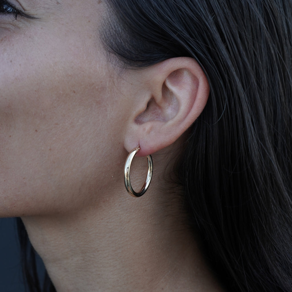 14K yellow gold earrings from Lico Jewelry, featuring a model wearing the 20 mm hoops