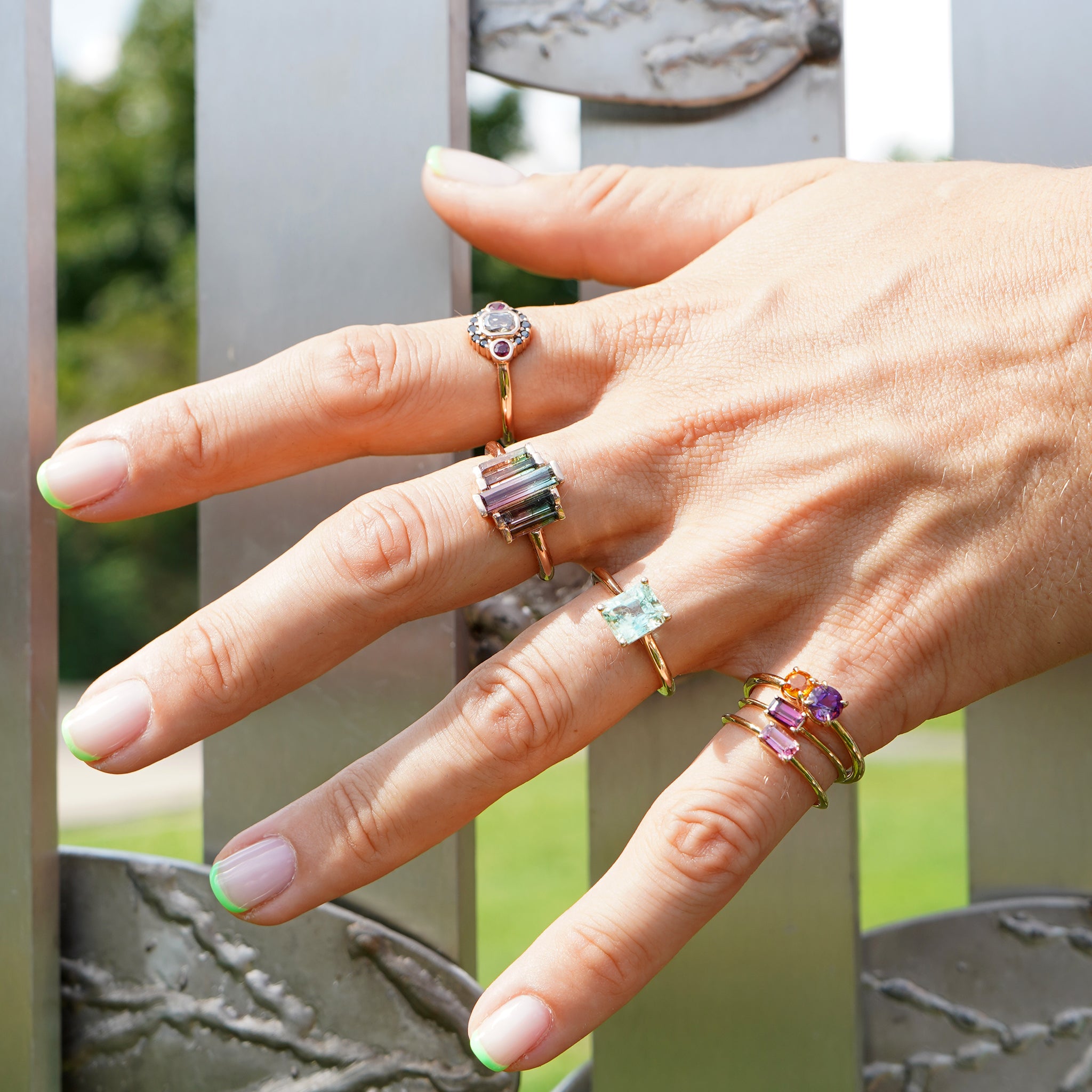 Woman showing off her stylish layered ring look featuring the Iris Flower Ring in solid 14k yellow gold with genuine amethyst and citrine from Lico Jewelry Montreal