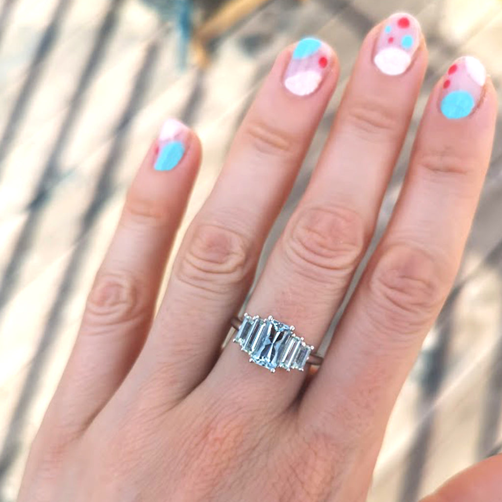 Woman's hand with blue and white nail polish design wearing Marine Deco Ring on middle finger, handcrafted by Lico Jewelry