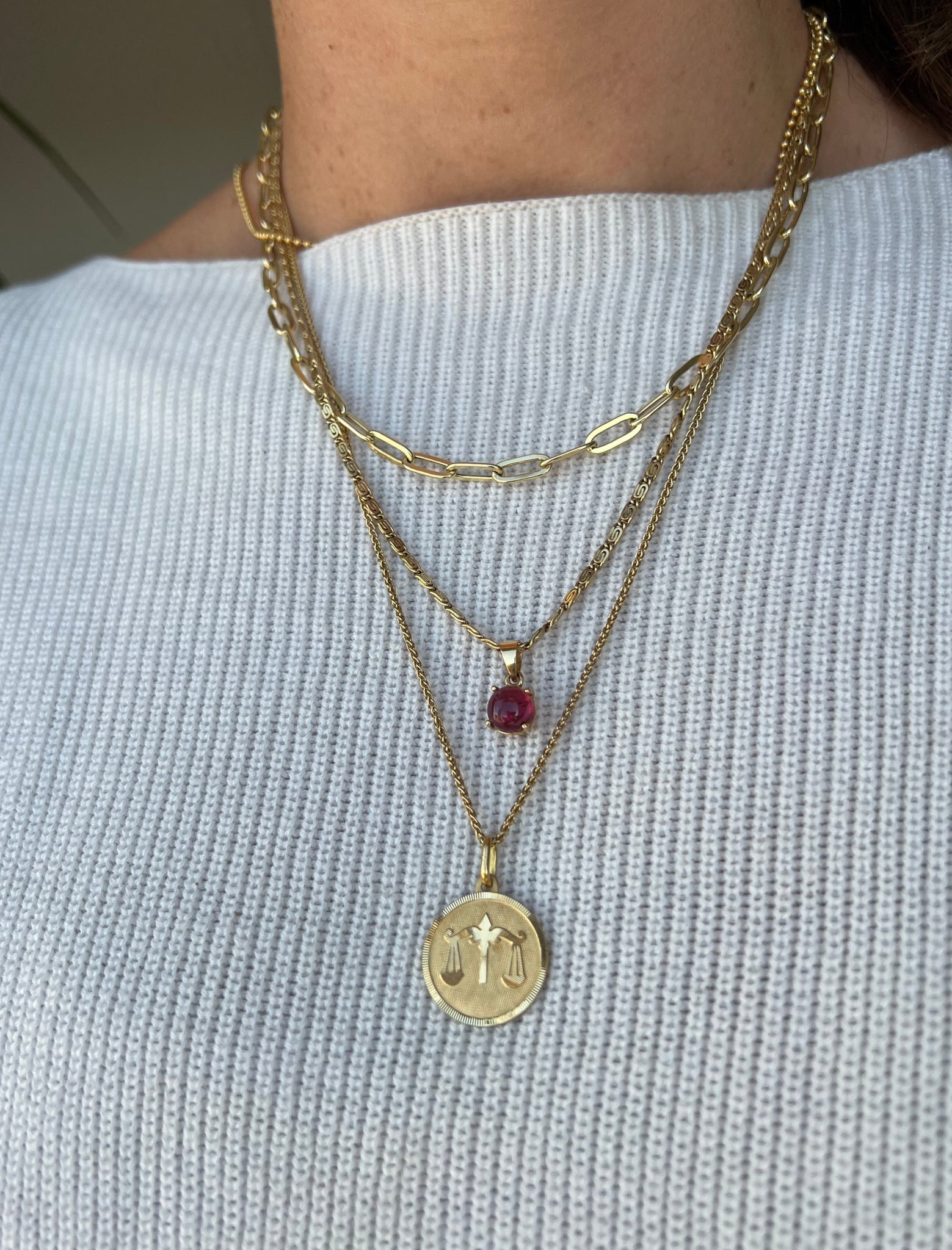 Vintage 18K Libra medallion pendant from Lico Jewelry in Montreal, styled with other gold necklaces and charms.