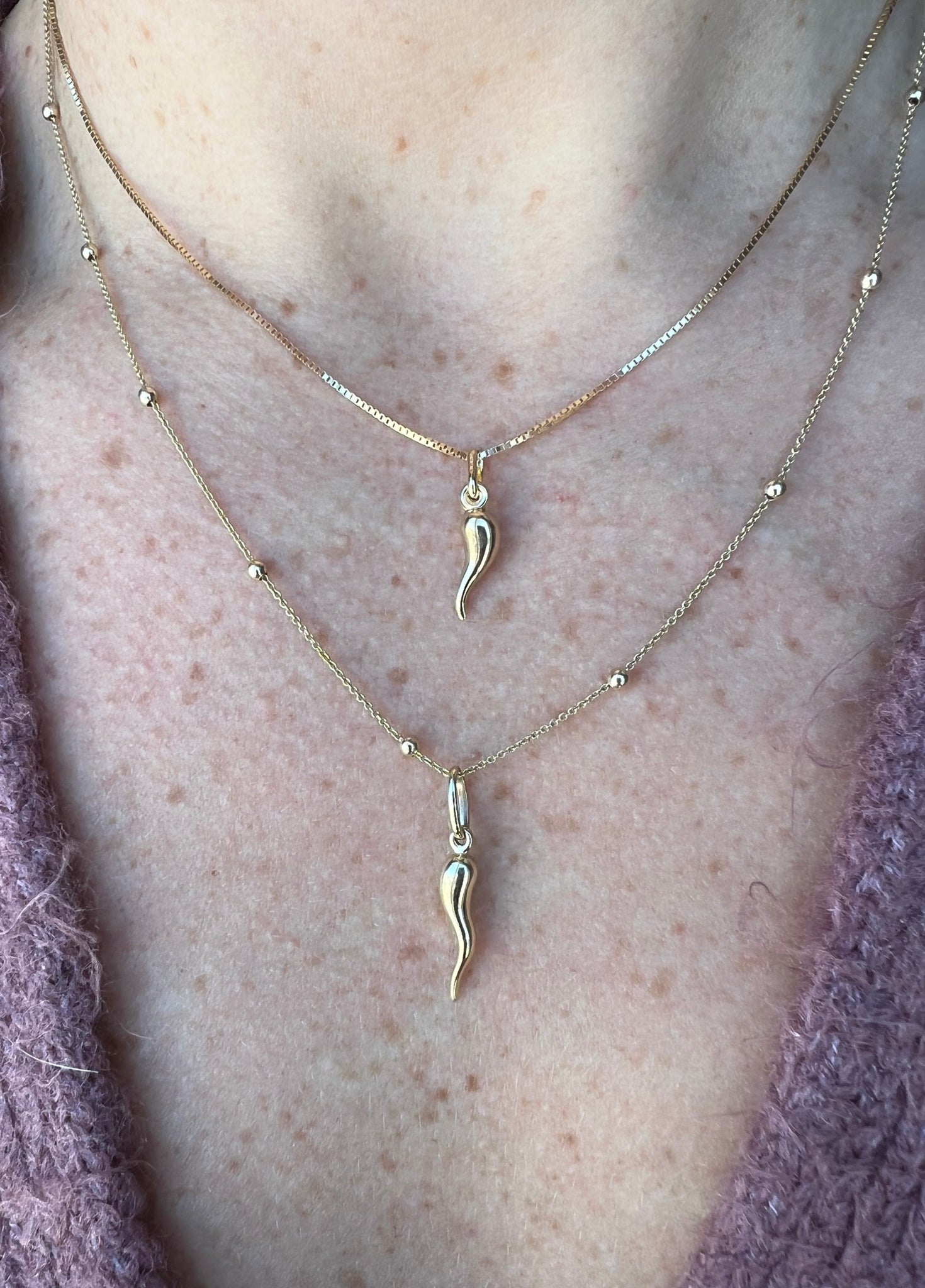 Woman wearing a variety of stylish necklaces, including the Cornicello charm by Lico Jewelry.