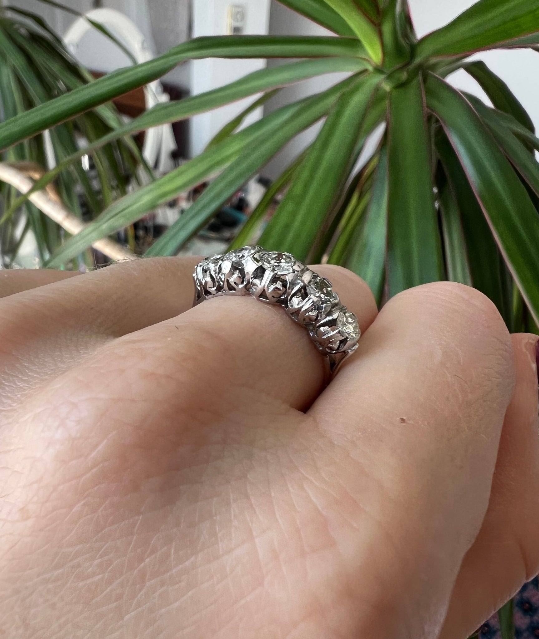 Lico Jewelry Montreal - Vintage 18k diamond ring on hand with bent fingers and green plant in background