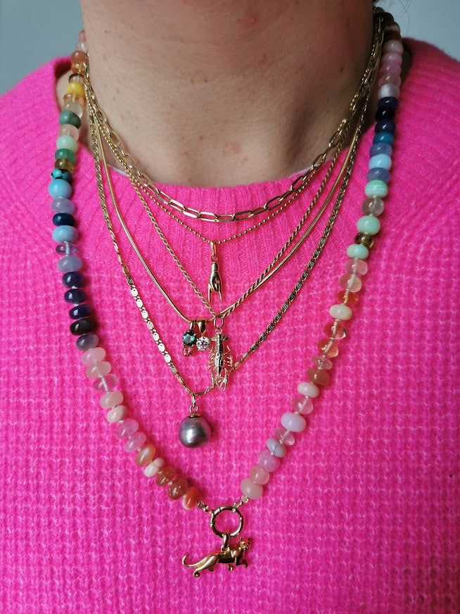 Woman wearing lobster charm on necklace layered with other necklaces and bright pink shirt - Lico Jewelry, Montreal.