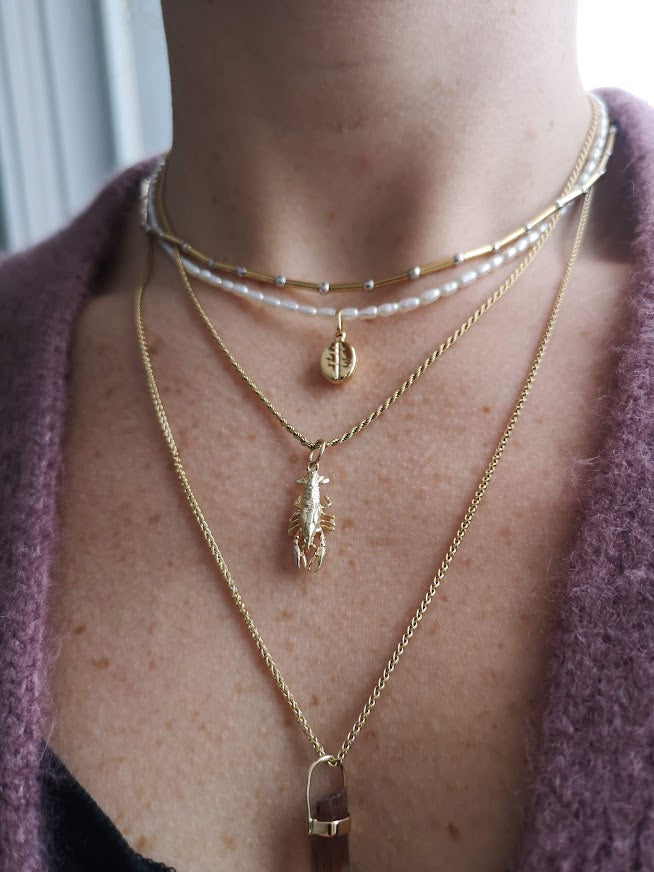 Woman modeling lobster charm on necklace chain with other layered necklaces - Lico Jewelry, Montreal