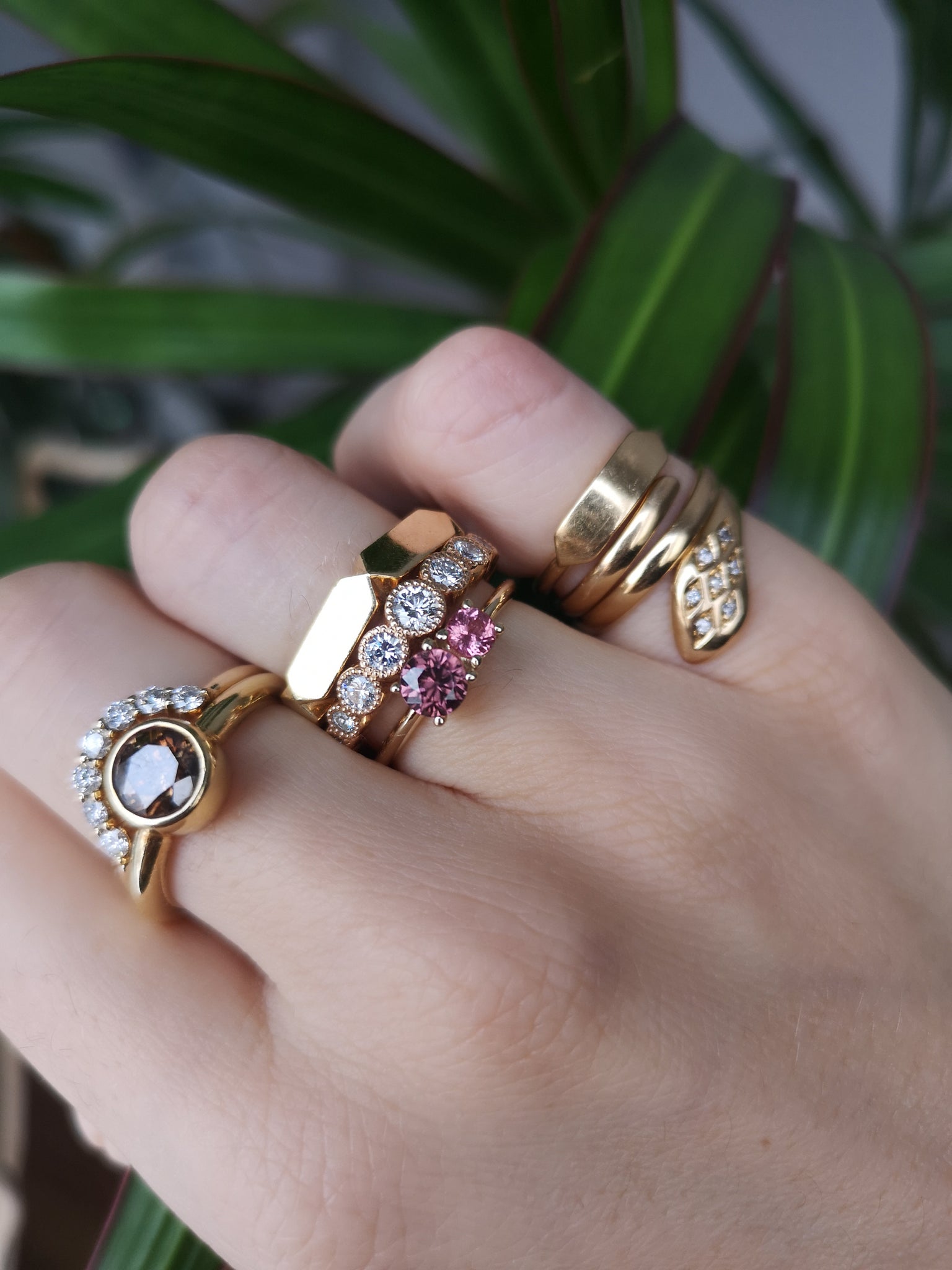 Mix and match the Muted Rose ring from Lico Jewelry with other rings for a personalized look. Featuring a natural pink-brown zircon and pink spinel set in 14k yellow gold. December and August birthstones. Available now from Lico Jewelry in Montreal with green plant in background