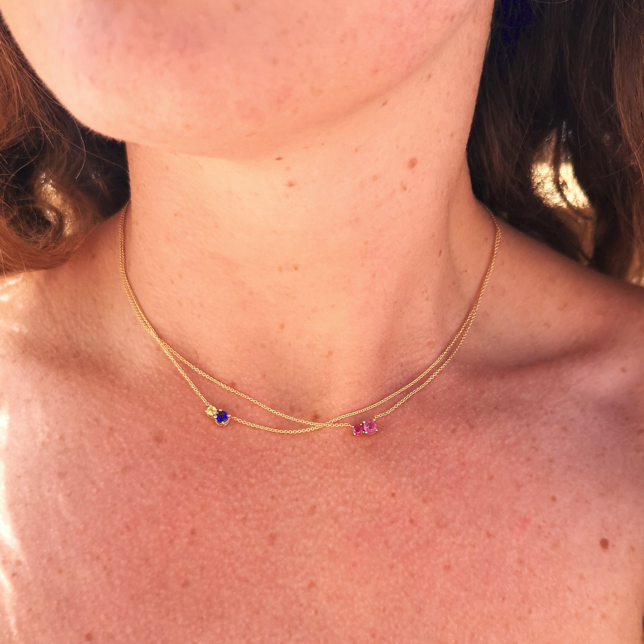 A woman's neck with the Royal Mimosa necklace on a thin chain, paired with another 2 stone necklace by Lico Jewelry.