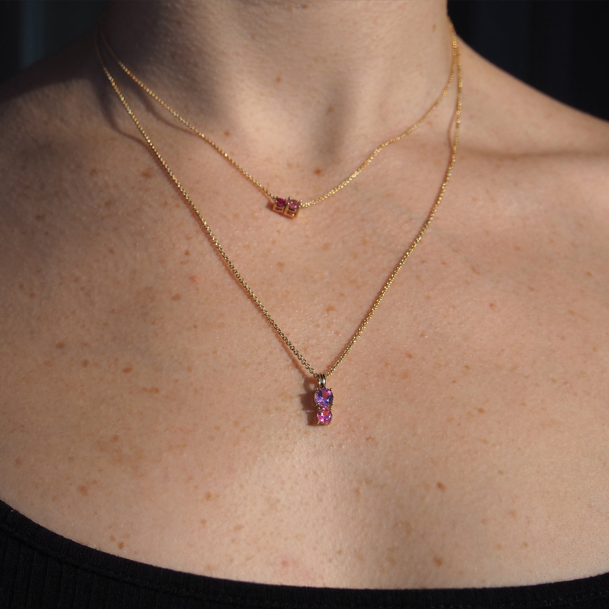 A woman wearing Lico Jewelry's Doll House pendants paired with other beautiful necklaces, based out of Montreal.