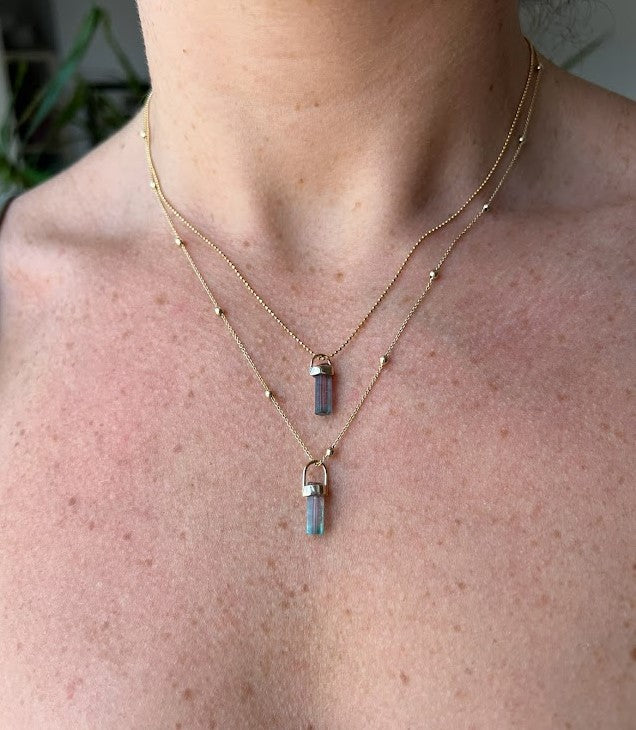 Woman wearing two necklaces with one tourmaline crystal pendant each, layering jewelry, Lico Jewelry