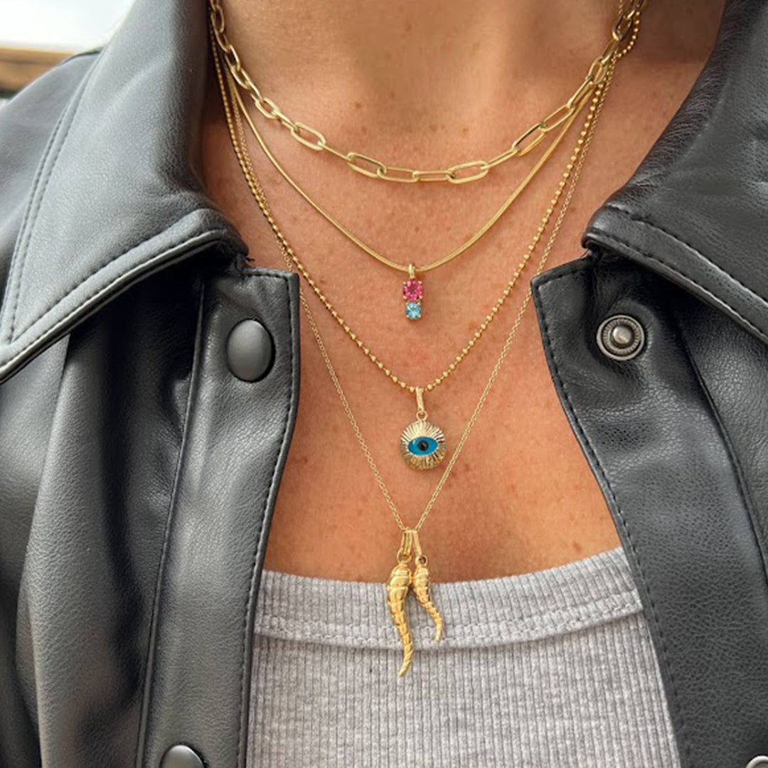 woman showing off her stylish layered necklace look featuring the Highschool Sweetheart Pendant in solid 14k yellow gold with genuine pink tourmaline and sky blue topaz from Lico Jewelry Montreal"     Reg